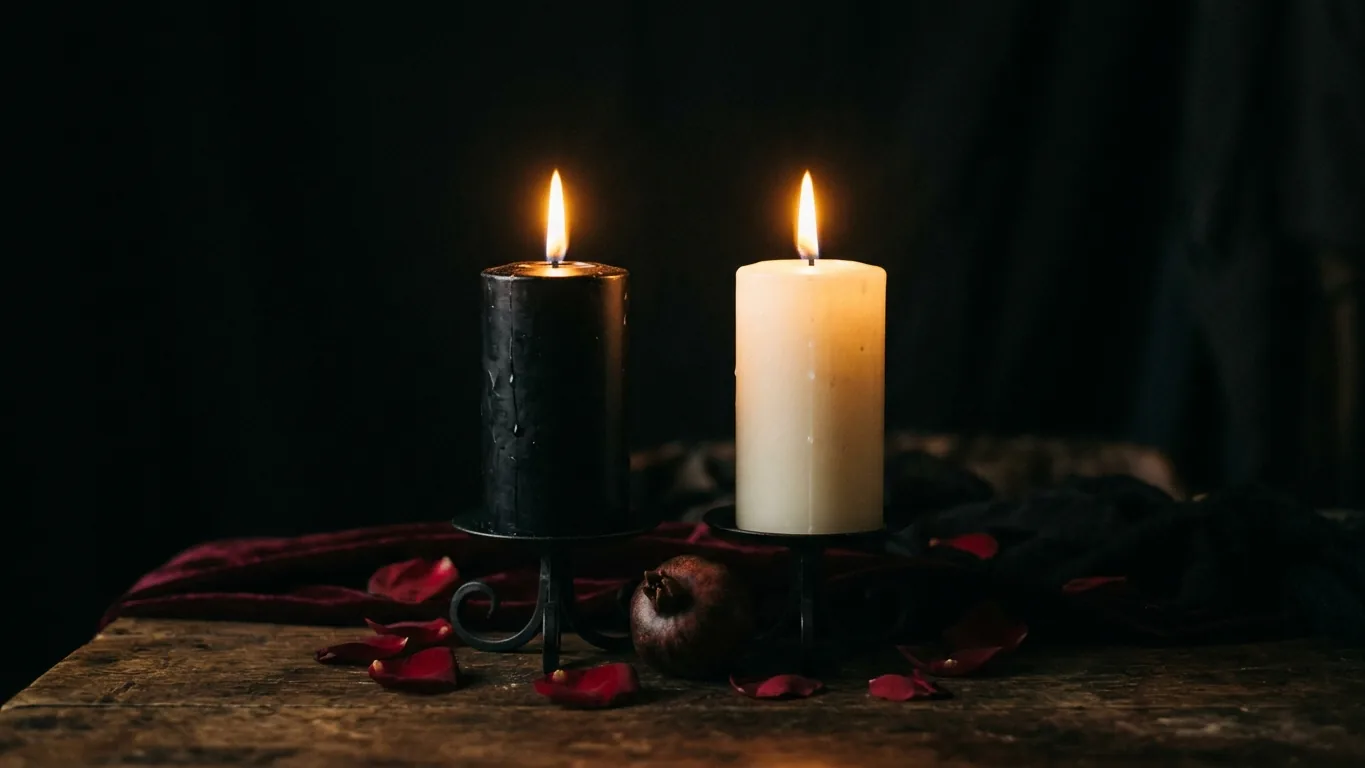 Black and white candles burning side by side