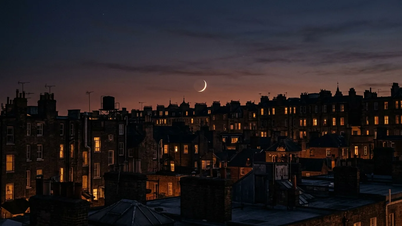 Thin new moon over city rooftops