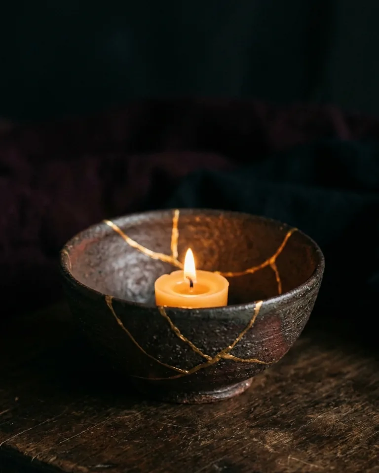Bowl mended with gold seams holding a candle