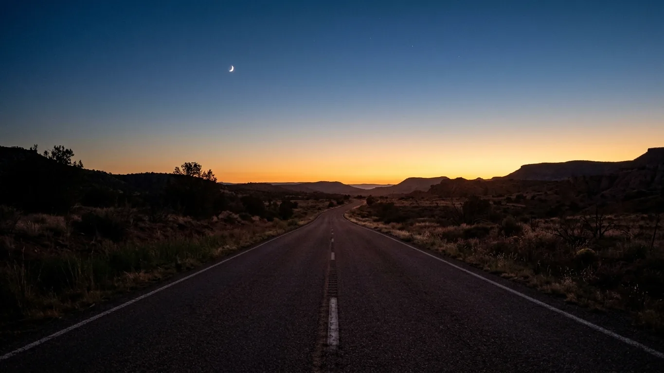 Waxing moon over an empty road at dusk